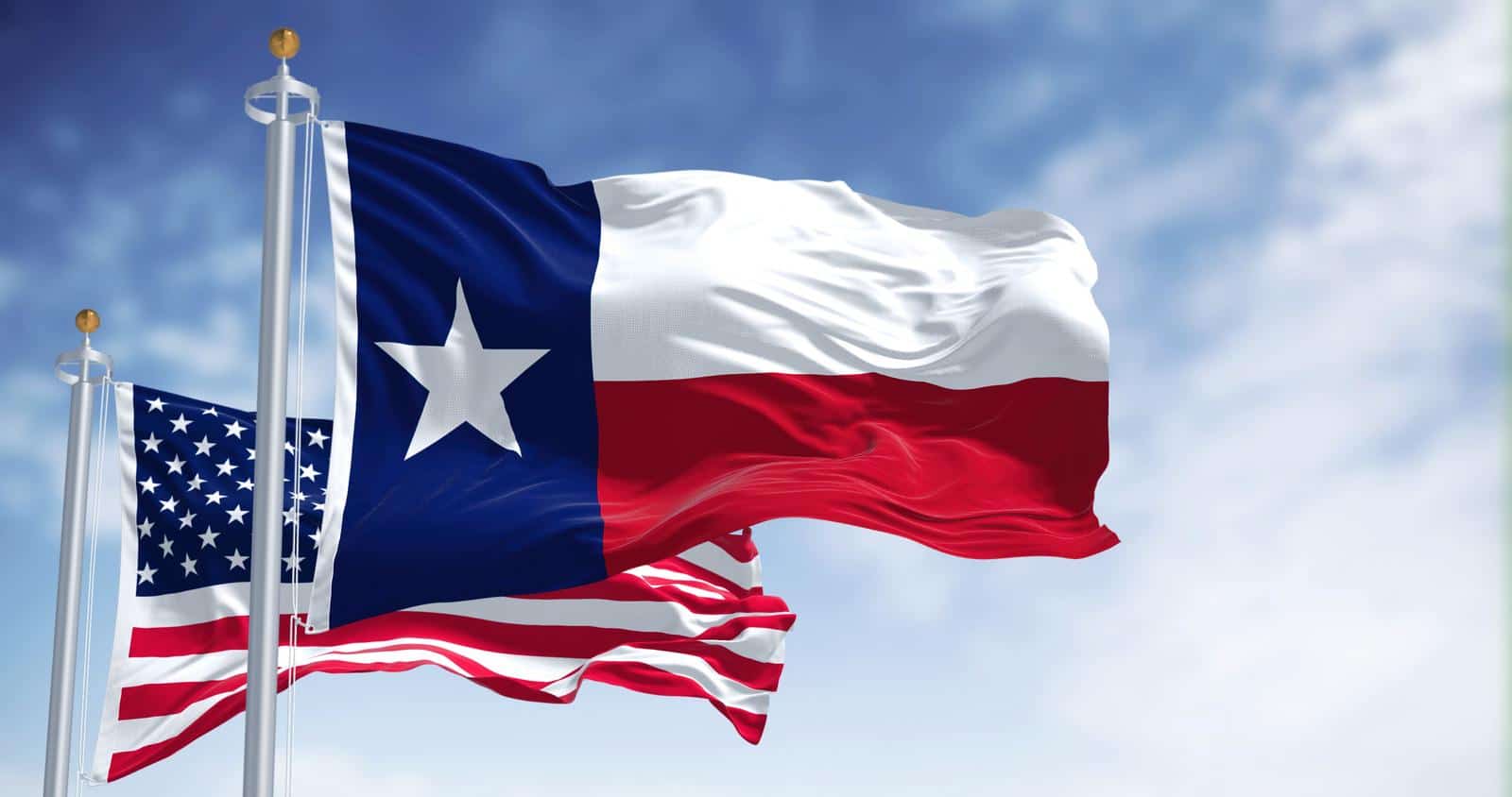The Texas state flag waving along with the national flag of the United States of America. Texas s a state in the South Central region of the United States.
