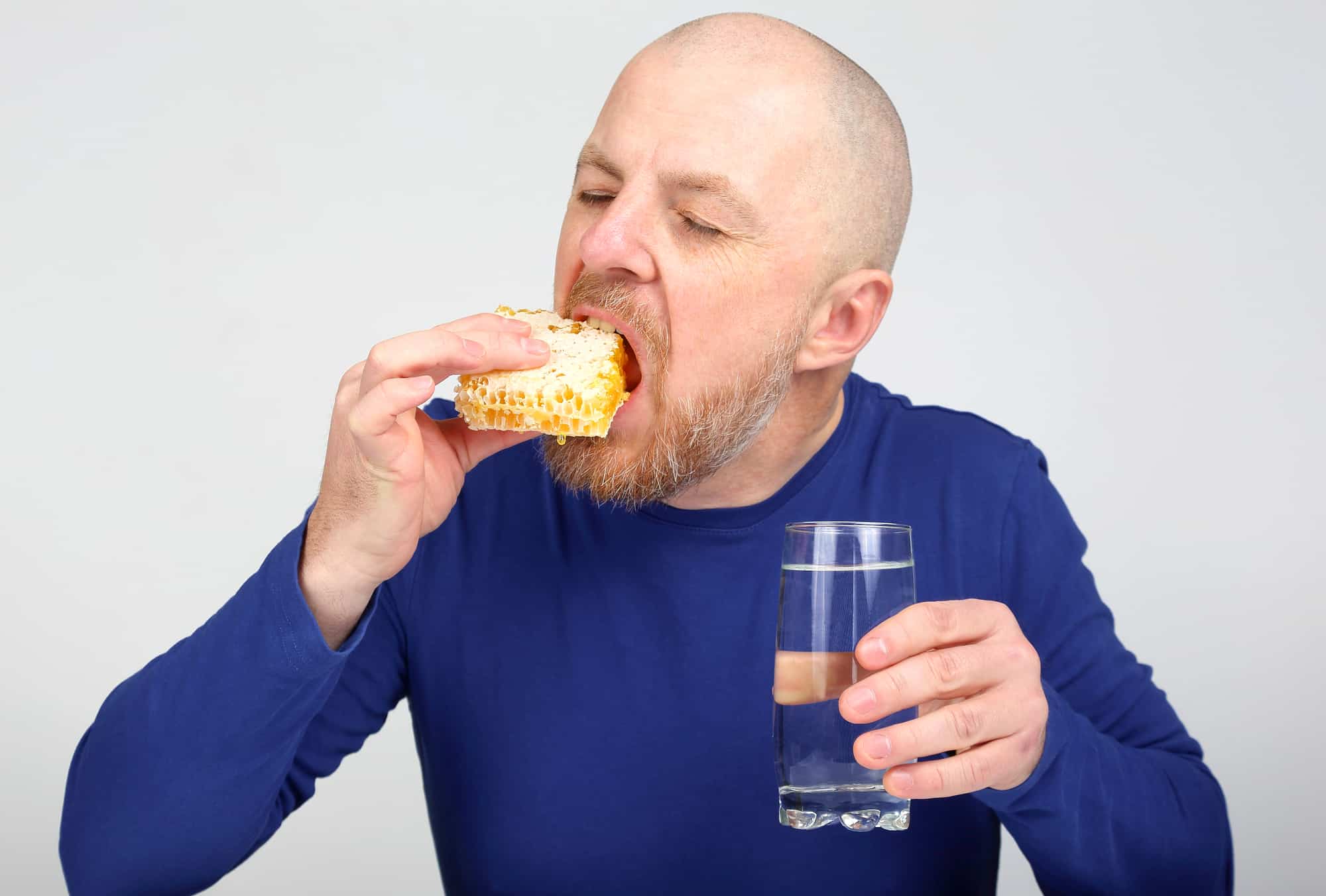 a man eating honeycomb.